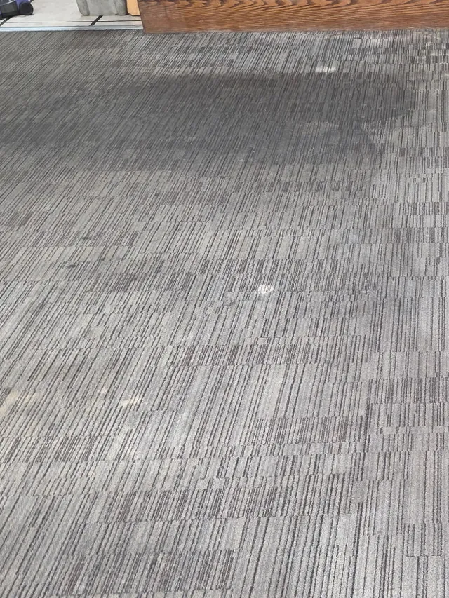 Restaurant carpet tile before cleaning, gray and dull with traffic lanes