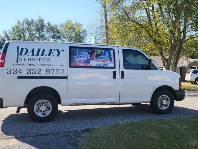 A white Dailey Services van with the logo and phone number